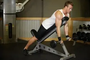 Lifting barbells for biceps on incline bench