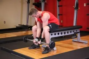 Lifting barbells for biceps narrow grip in the sitting position