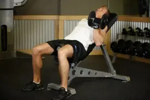 Alternately lifting dumbbells for biceps on incline bench