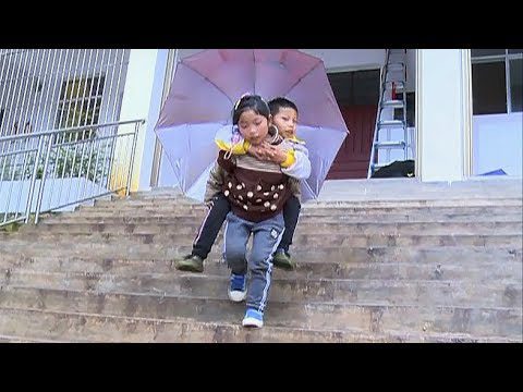 9-year-old girl carries her brother to school in her arms every day