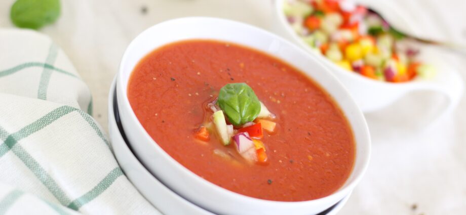 Crab soup with avocado, tomatoes and corn garnish