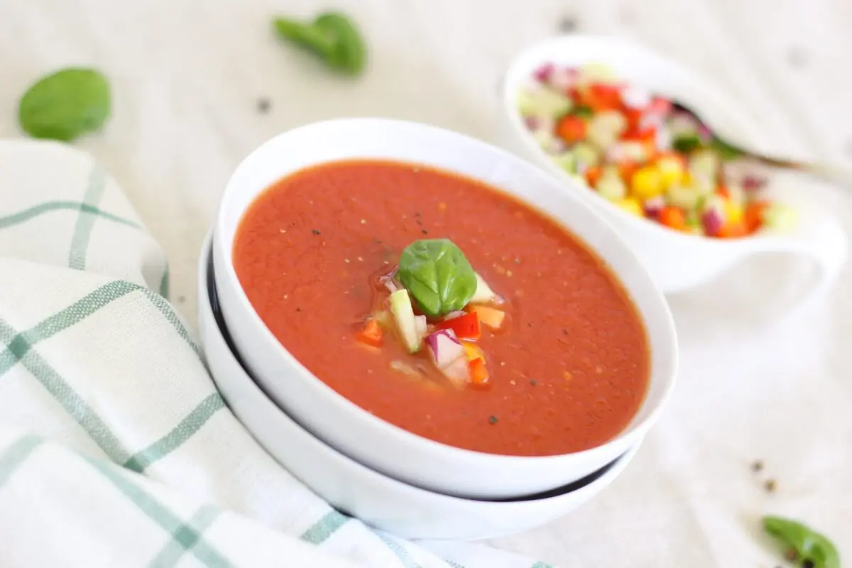 Crab soup with avocado, tomatoes and corn garnish