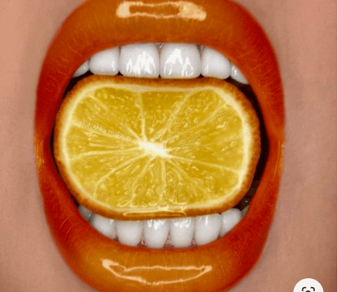 Vibrant paint colors: orange lips, lemon eyes, green nails