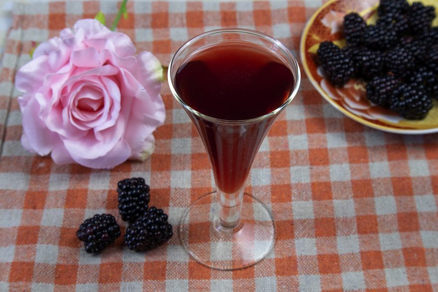 Homemade blackberry liqueur with lemon zest