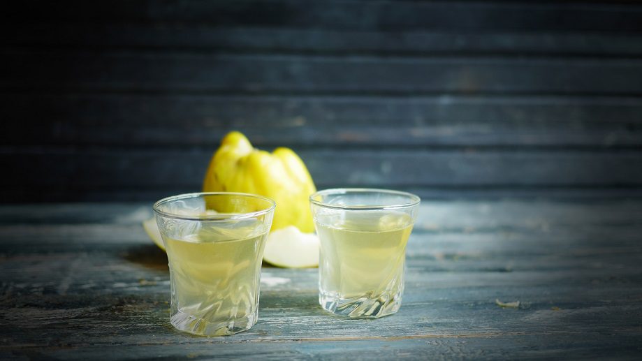 Quince pouring on vodka or alcohol