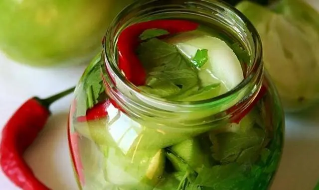 Harvesting green tomatoes for the winter in jars 