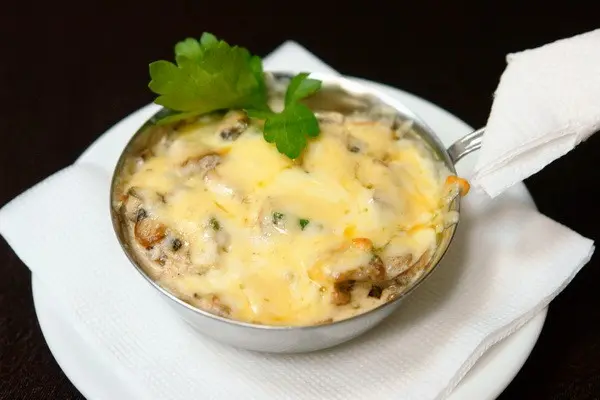 Julienne with mushrooms and cheese in the oven and in a frying pan