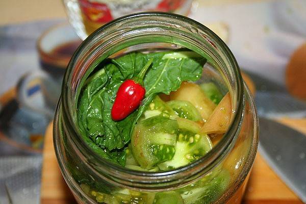 Salting green tomatoes in jars for the winter