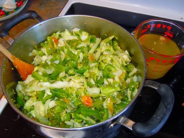 Sliced ​​marinated green tomatoes with hot peppers