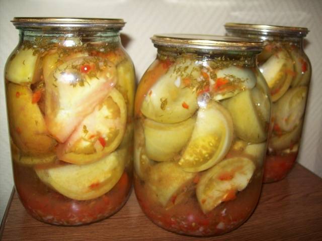 Sliced ​​marinated green tomatoes with hot peppers