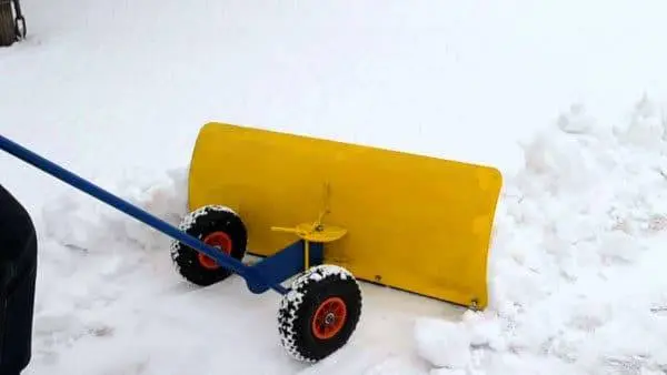 Snow scraper on wheels
