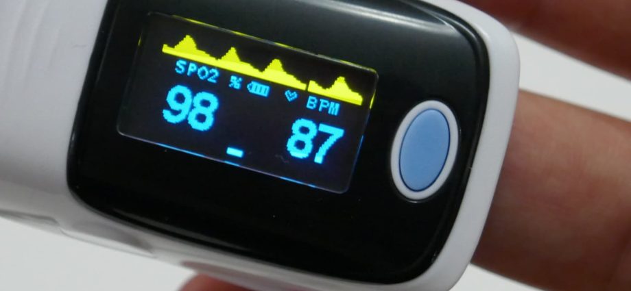 The doctor explains how to read the data from the pulse oximeter